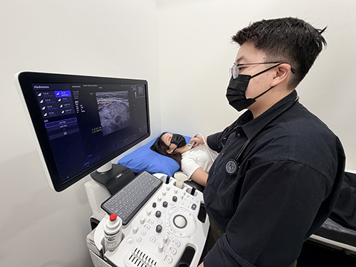 Doctor performing an ultrasound scan on a patient at Klinik Tong & Surgeri