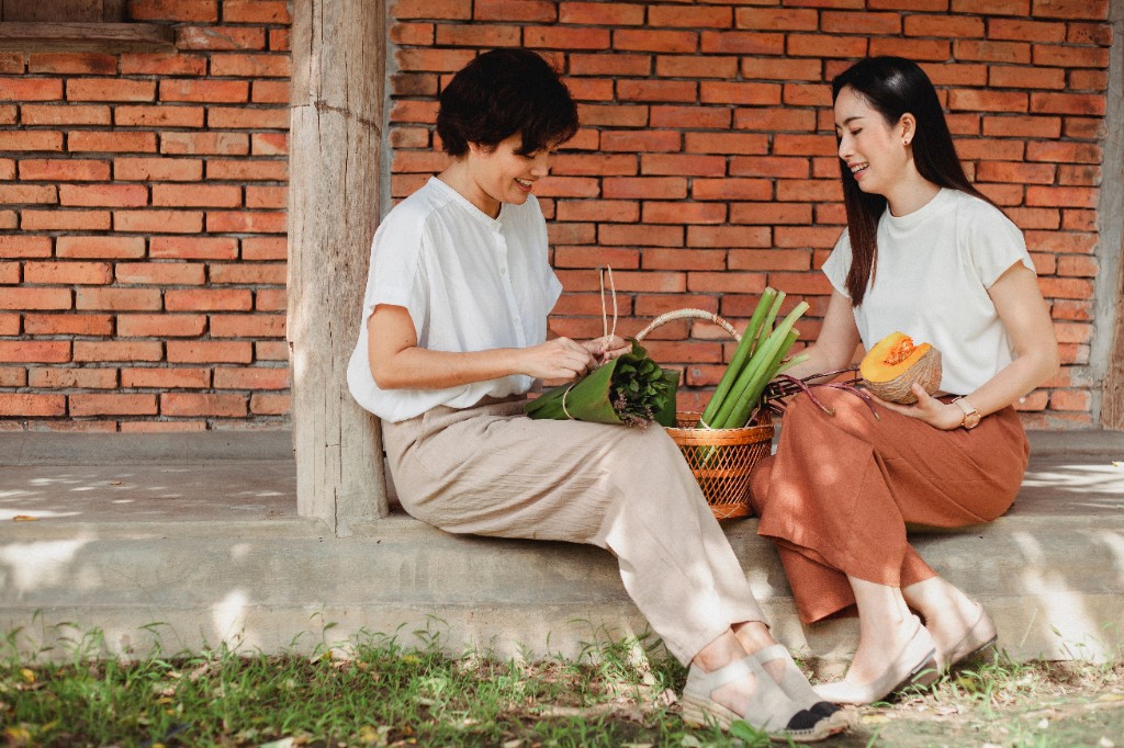 两位女性在阳光门廊准备新鲜蔬菜